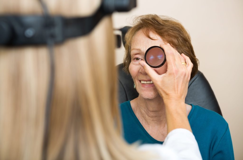 A woman getting her peripheral vision tested by an optometrist.