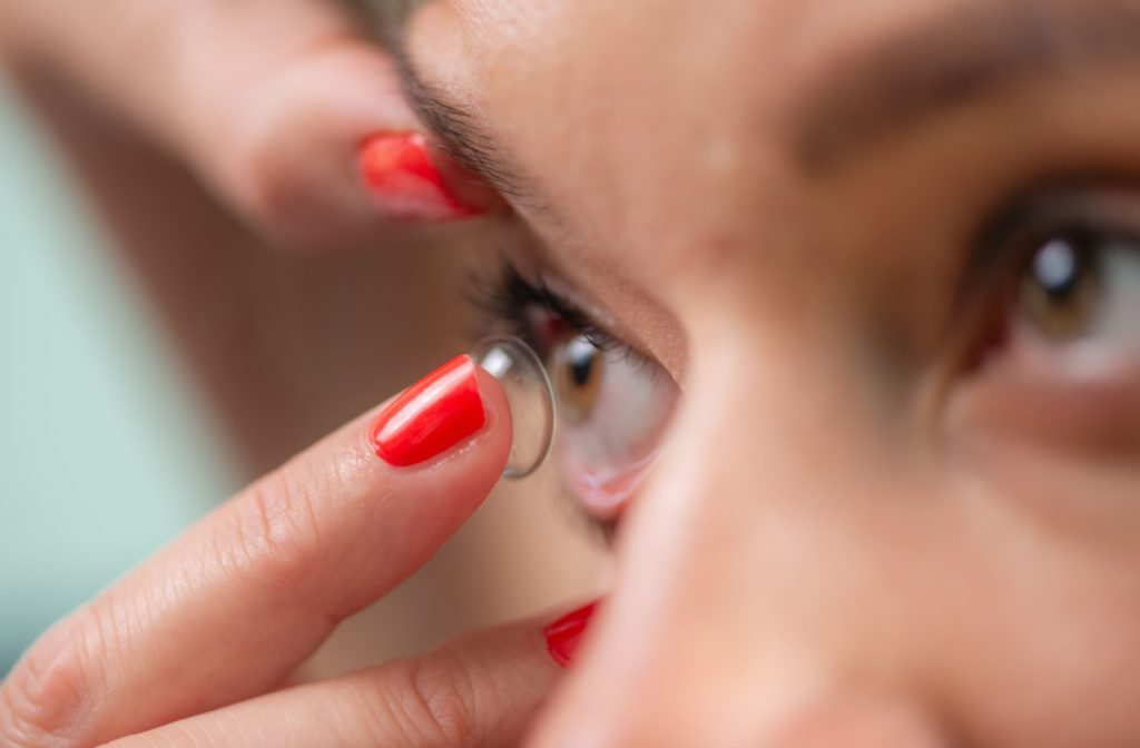 A close-up of a patient inserting a soft contact lens.