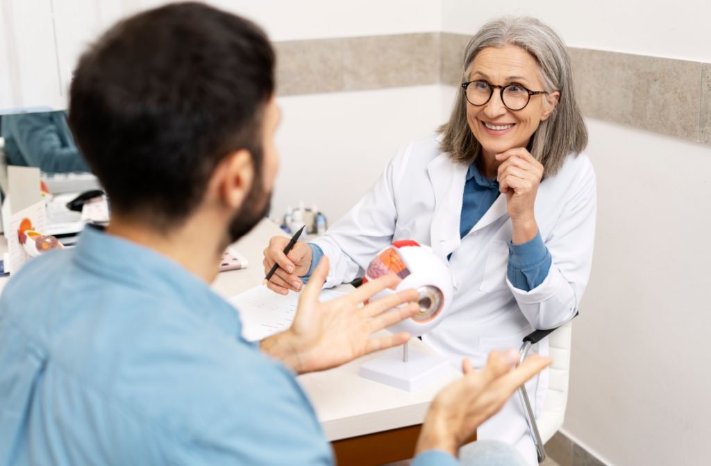 A man discussing their family eye history with a smiling eye doctor.