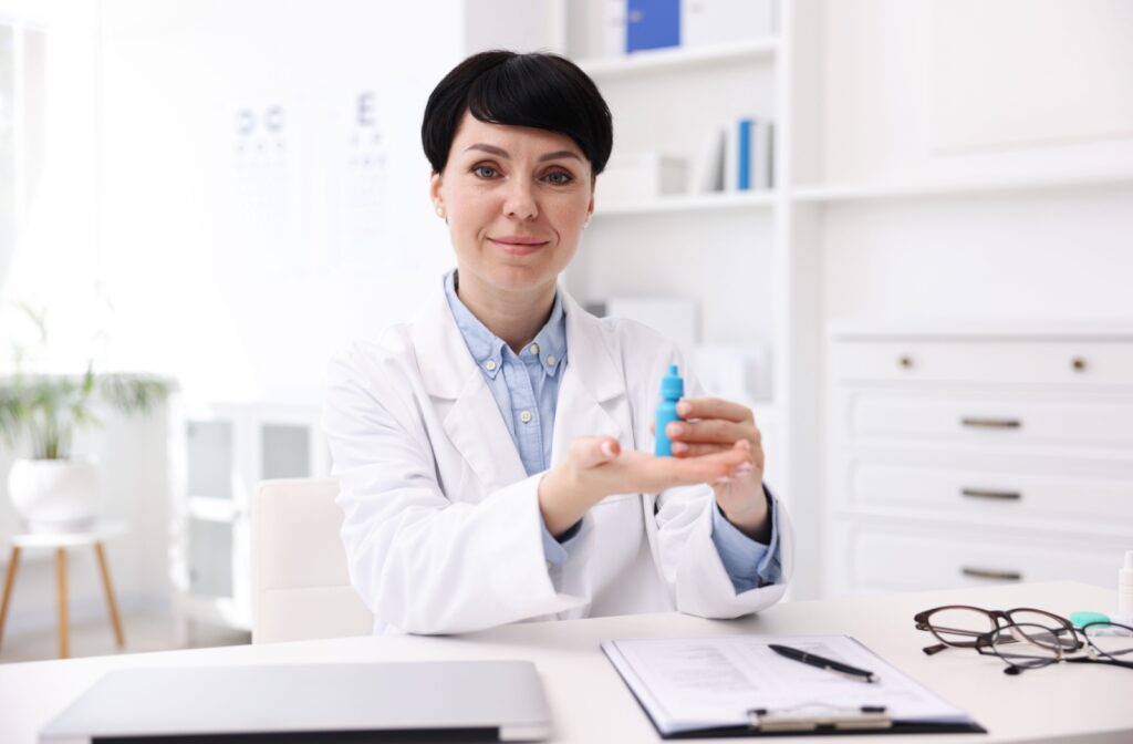 Optometrist holding a bottle of eye drops in a clinic setting.